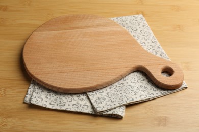 Photo of New cutting board and napkin on wooden table