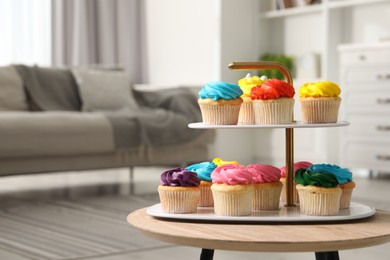 Delicious cupcakes with bright cream on wooden table indoors