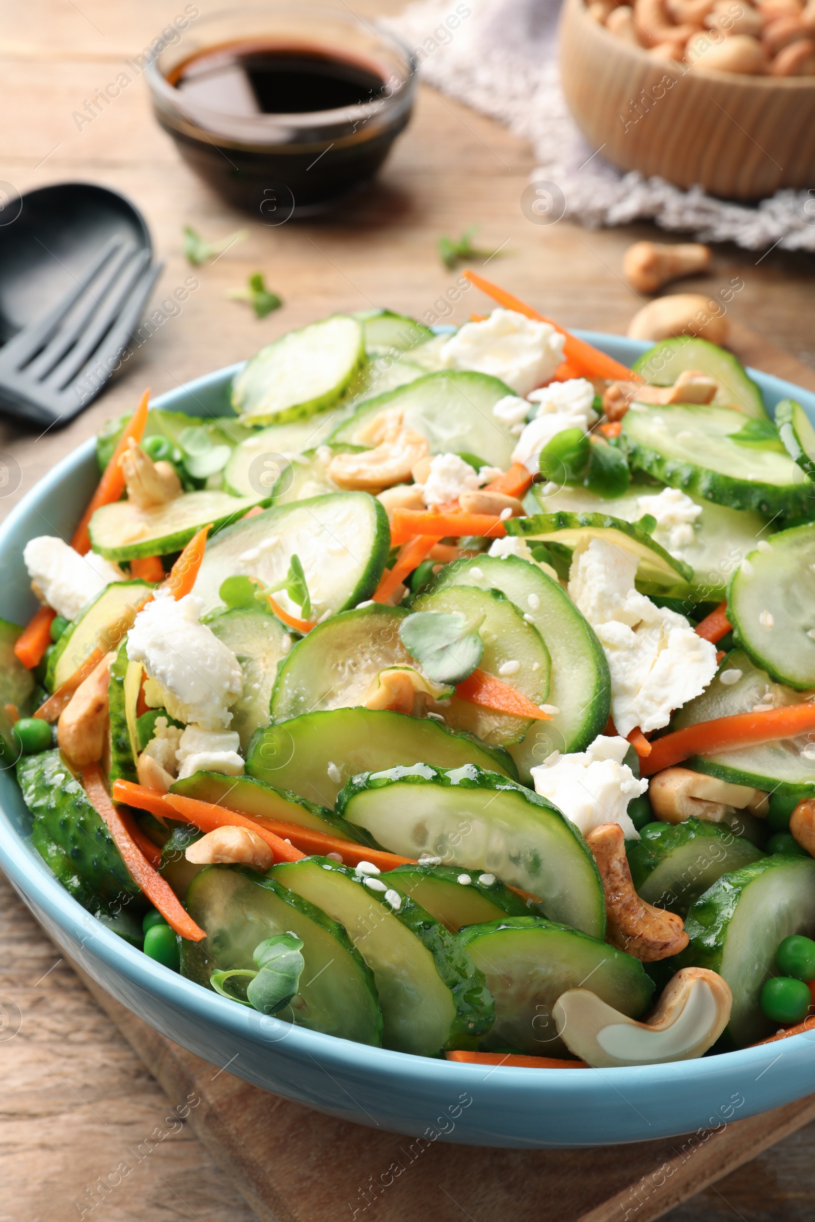 Photo of Delicious cucumber salad on wooden table, closeup