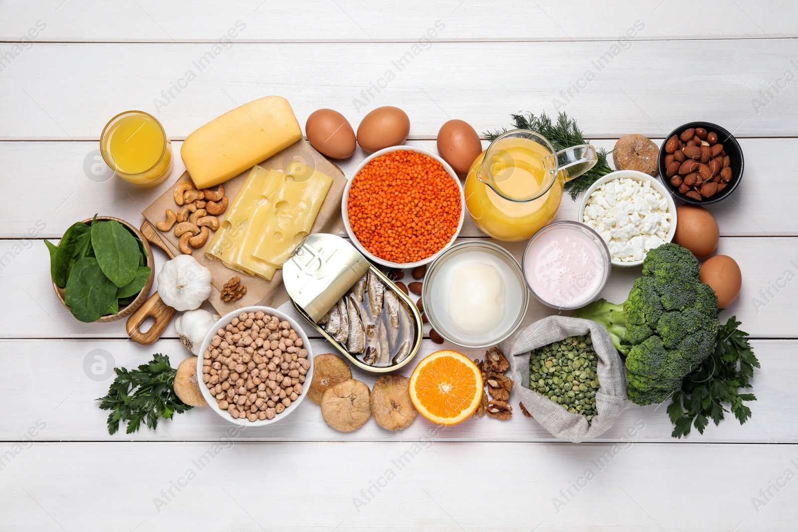 Photo of Set of natural food high in calcium on white wooden table, flat lay