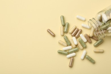 Vitamin pills and bottle on beige background, top view. Space for text