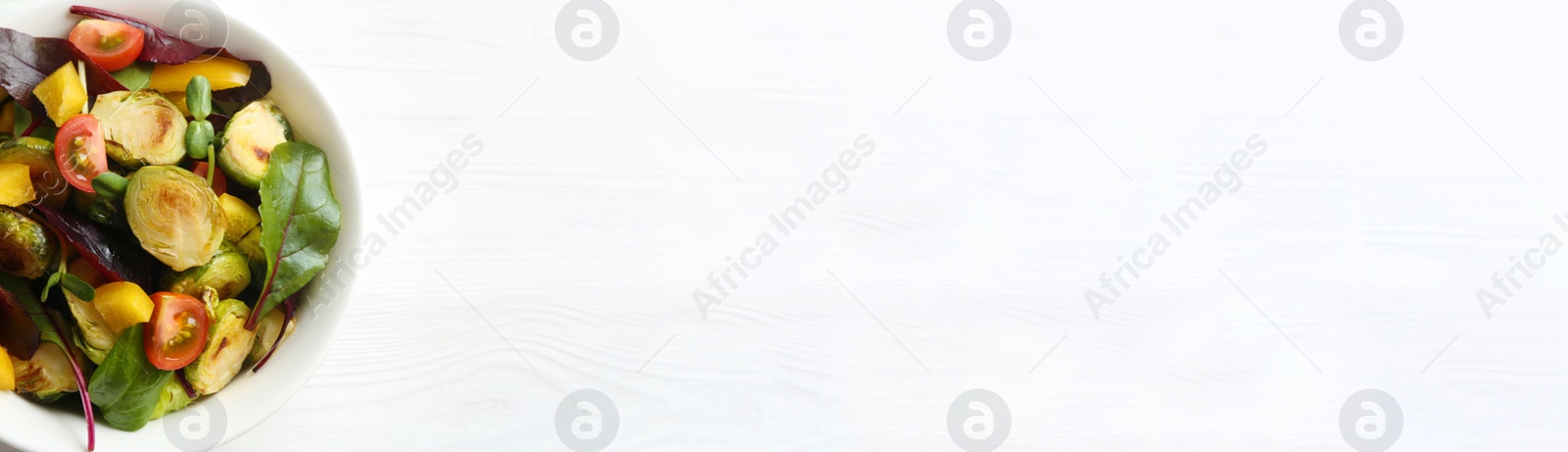 Image of Delicious salad with roasted Brussels sprouts and space for text on white wooden table, top view. Banner design 