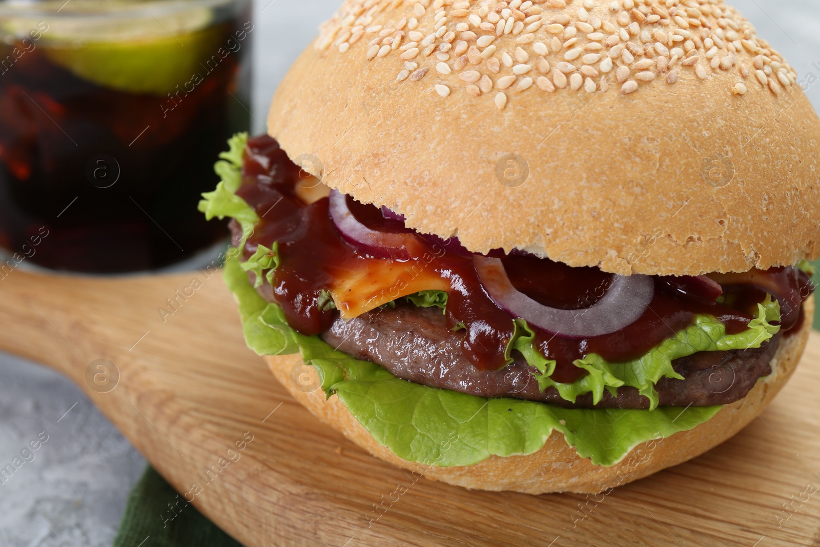 Photo of Board with delicious cheeseburger on table, closeup