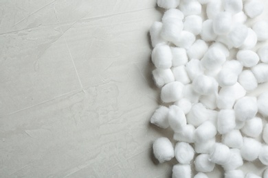 Photo of Many cotton balls and space for text on grey stone background, top view