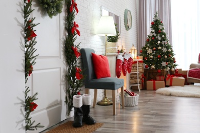 Stylish interior with beautiful Christmas tree and decorative fireplace