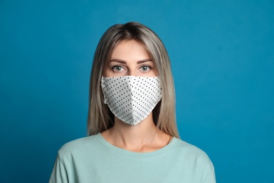 Young woman in protective face mask on blue background