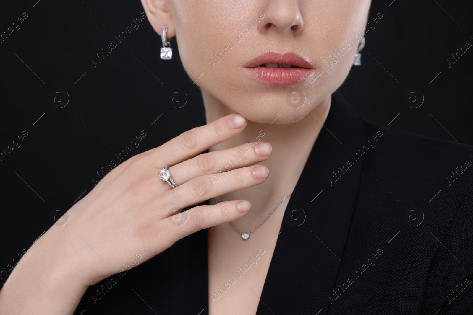 Photo of Woman with elegant jewelry on black background, closeup