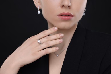 Photo of Woman with elegant jewelry on black background, closeup