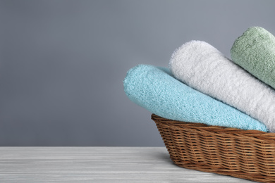 Fresh towels on wooden table, space for text