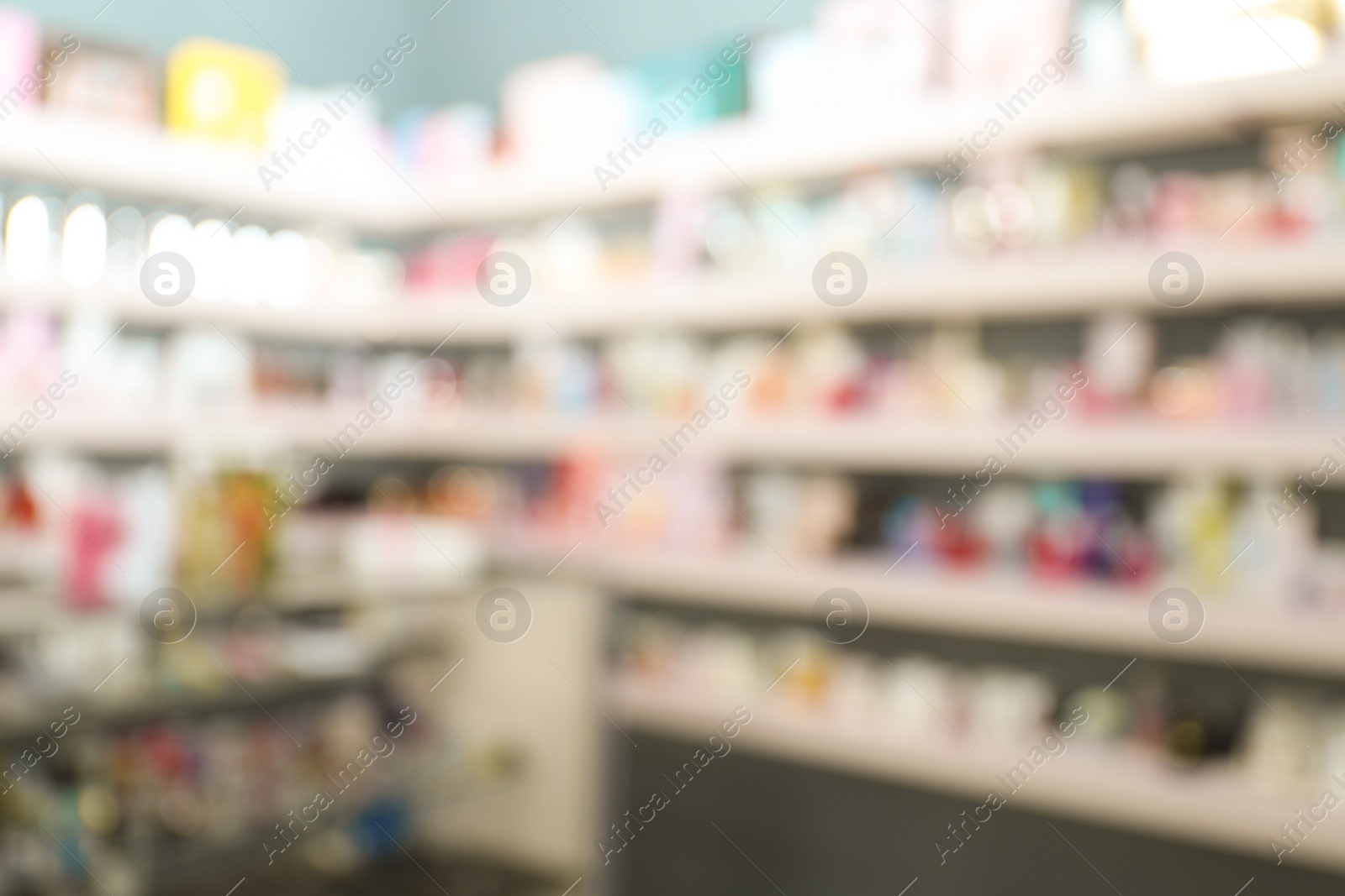 Photo of Blurred view of counter and shelves with perfume bottles in shop