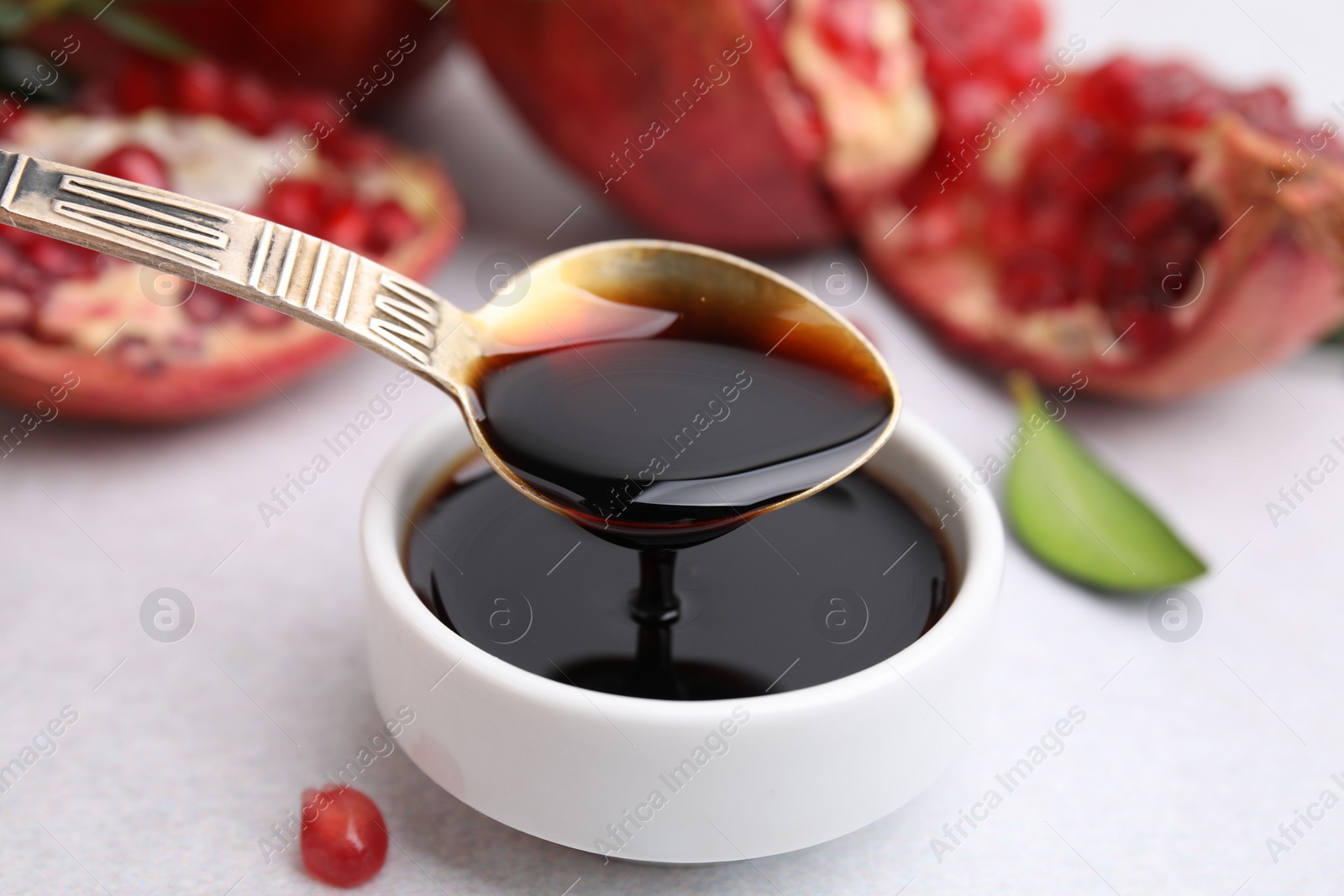 Photo of Tasty pomegranate sauce on light table, closeup