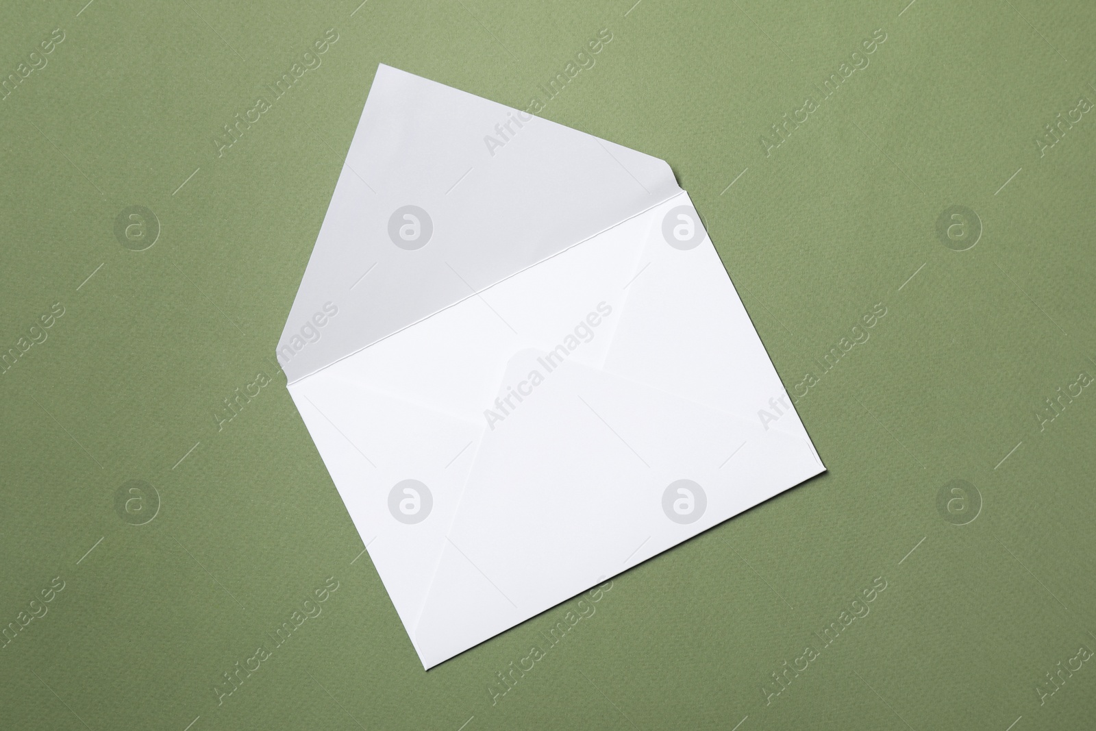 Photo of Letter envelope on green background, top view