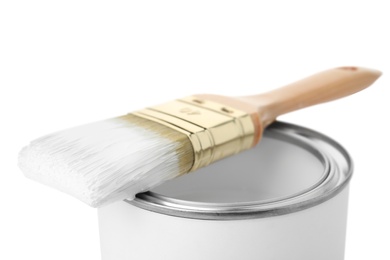 Photo of Paint can with brush on white background, closeup