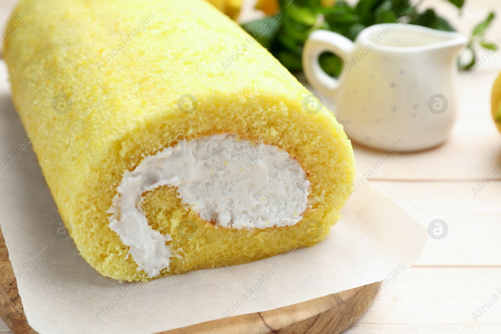 Photo of Delicious cake roll on light wooden table, closeup