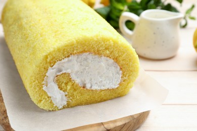 Delicious cake roll on light wooden table, closeup