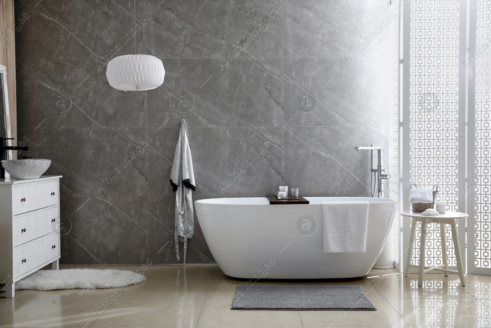 Photo of Modern white tub and chest of drawers with sink in bathroom. Interior design