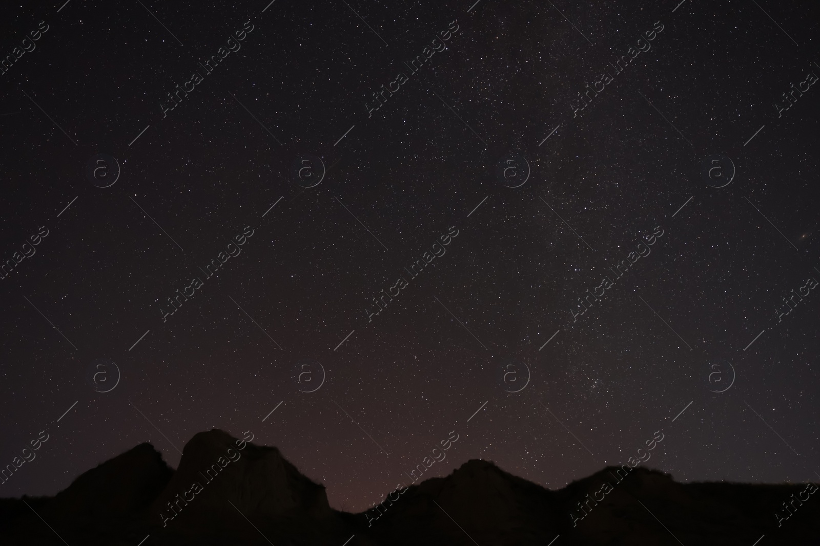 Photo of Picturesque view of starry sky at night over hill