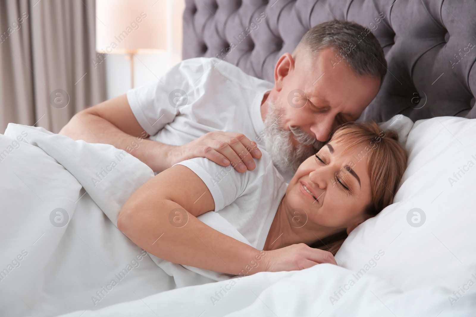 Photo of Mature couple together in bed at home