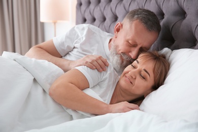 Photo of Mature couple together in bed at home