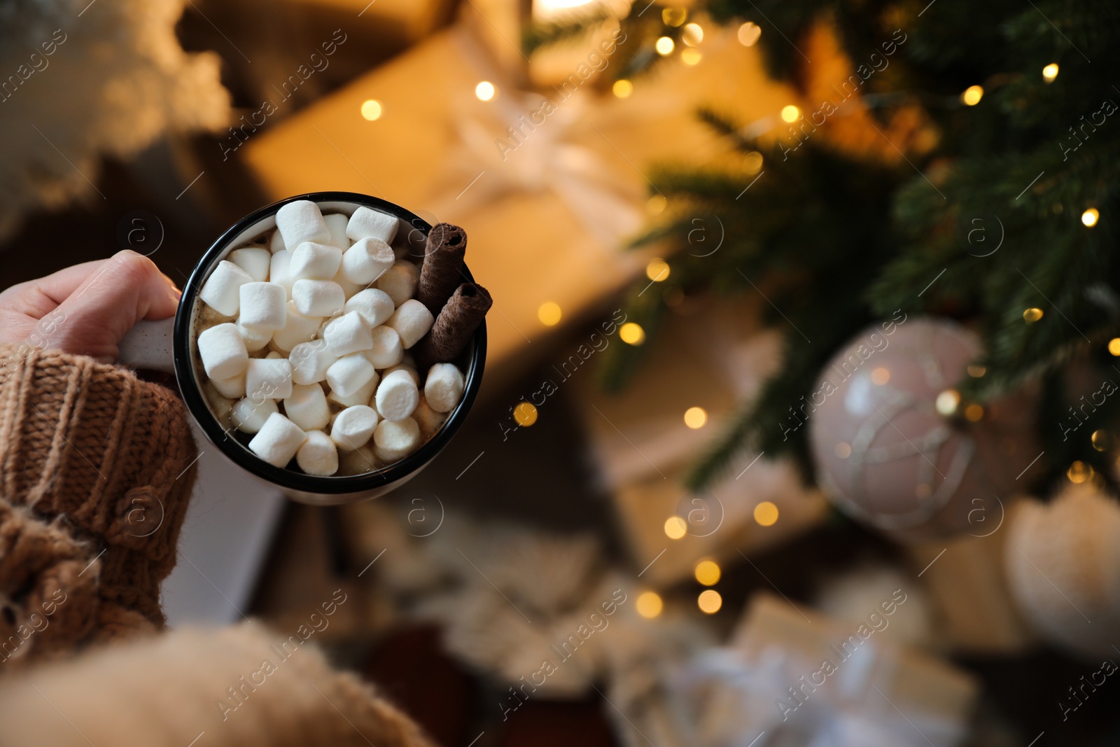 Photo of Woman with cup of cocoa indoors, top view. Christmas mood