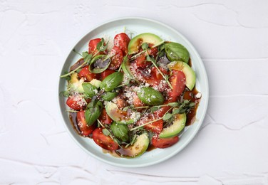 Photo of Tasty salad with balsamic vinegar on white textured table, top view