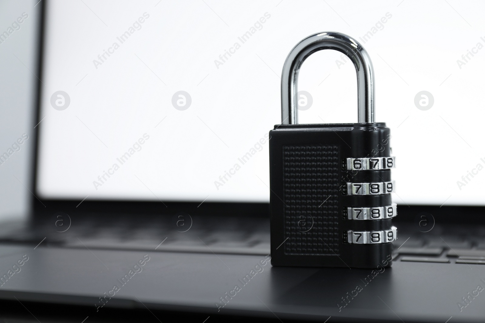 Photo of Cyber security. Metal combination padlock on laptop, closeup. Space for text