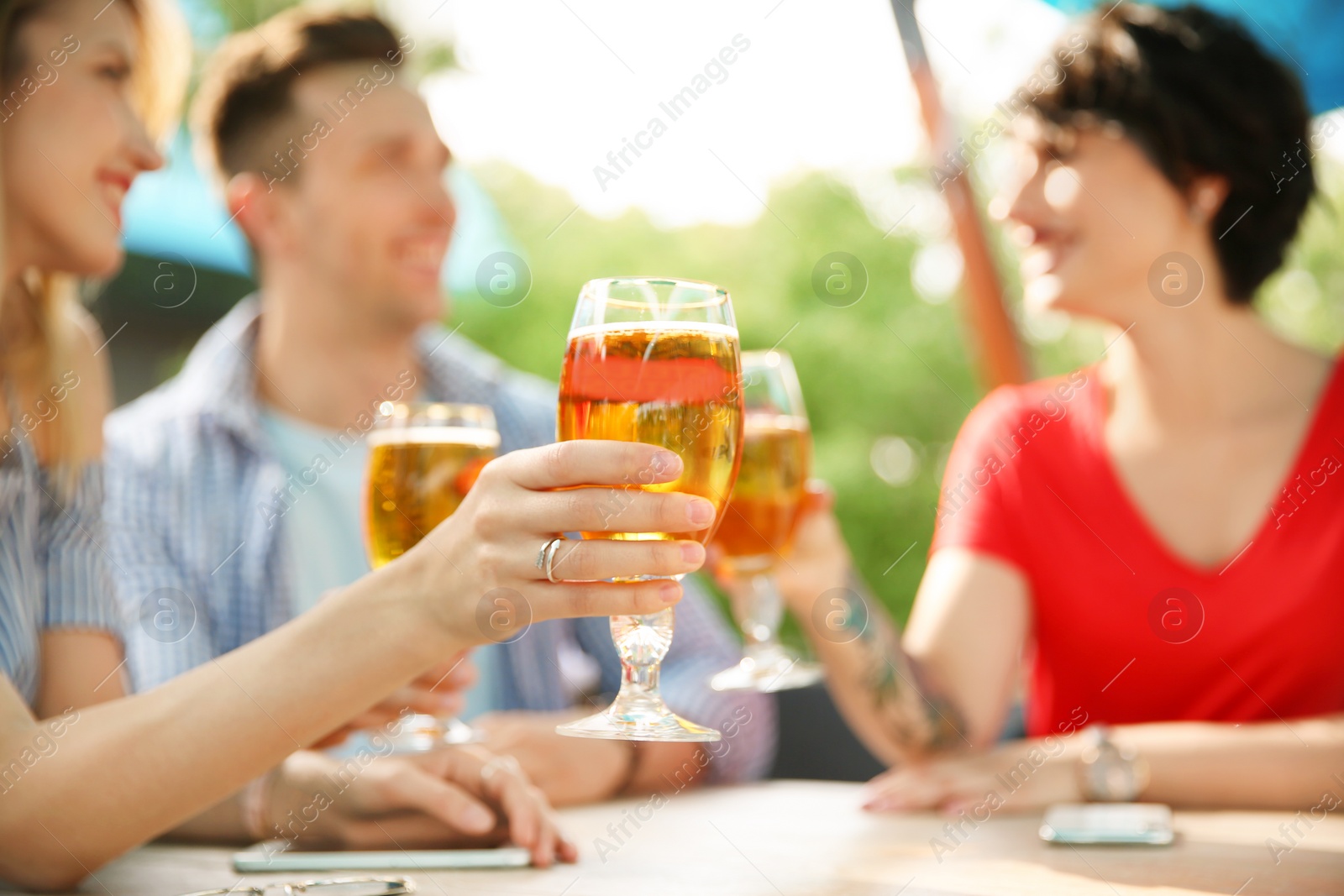 Photo of Young people with glasses of cold beer at table