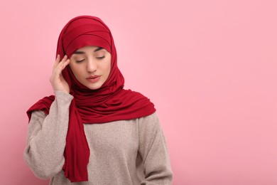 Portrait of Muslim woman in hijab on pink background, space for text