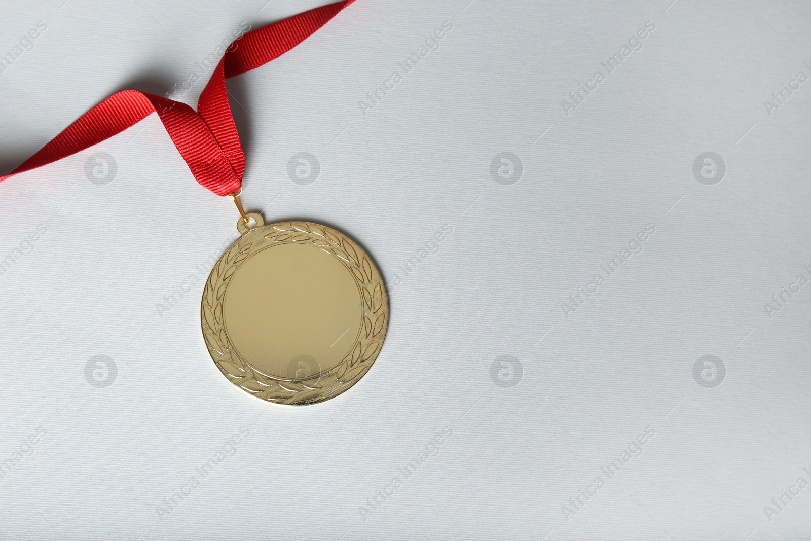 Photo of Gold medal on white background, top view. Space for design