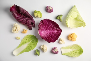 Different fresh cabbages on white background, top view. Healthy food