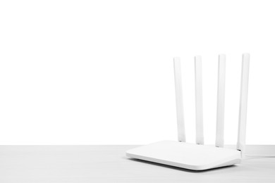 Photo of New modern Wi-Fi router on wooden table against white background. Space for text
