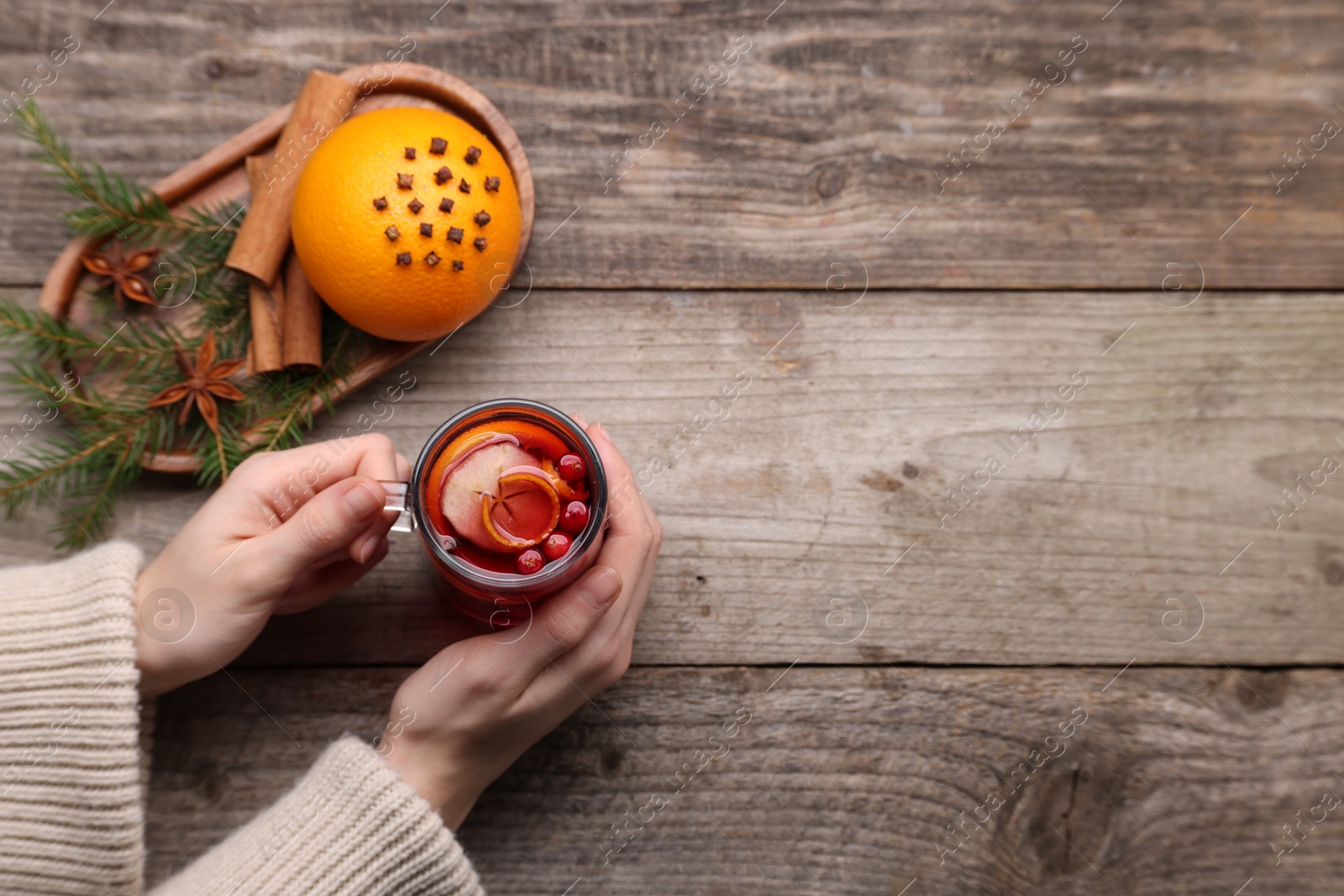 Photo of Woman with cup of aromatic mulled wine, top view. Space for text