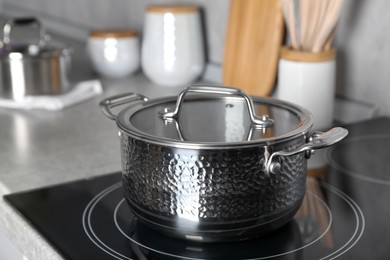 Photo of Pot with lid on cooktop in kitchen. Cooking utensil