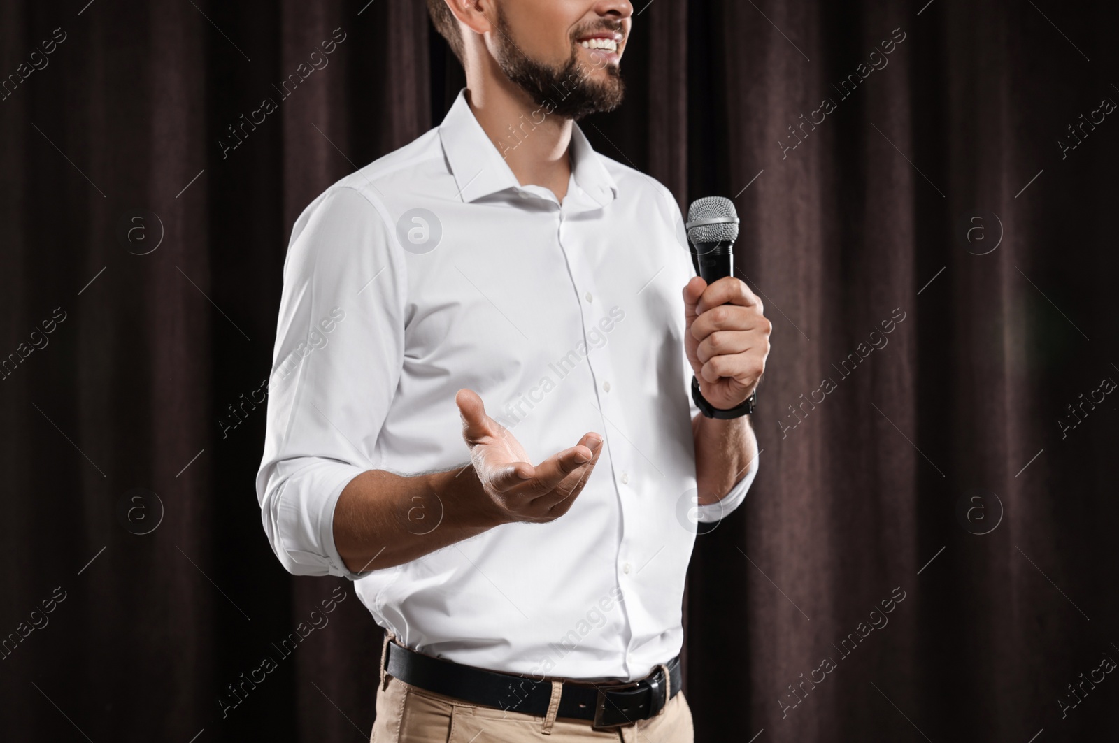 Photo of Motivational speaker with microphone performing on stage, closeup