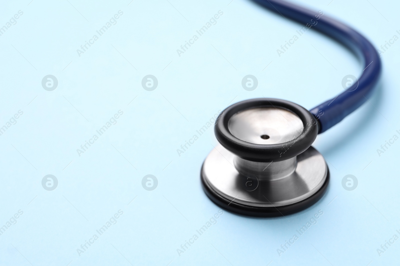 Photo of Stethoscope on light blue background, closeup. Space for text