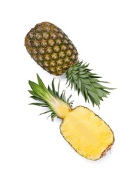 Whole and cut ripe pineapples on white background, flat lay. Space for text
