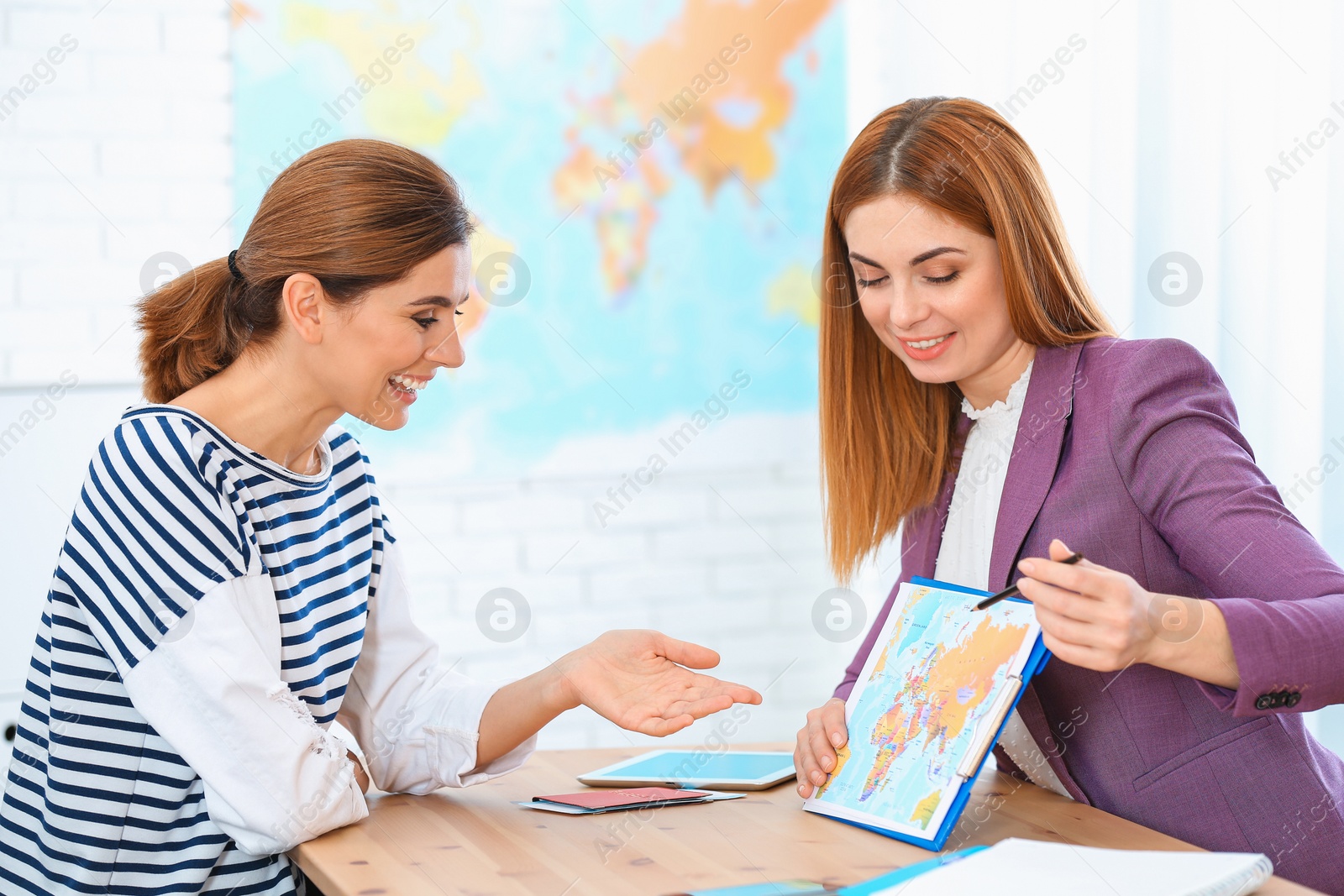 Photo of Female manager consulting client in travel agency