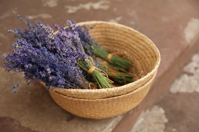 Wicker basket with lavender flowers on cement floor outdoors