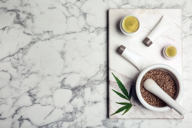 Flat lay composition with hemp lotion and space for text on marble background