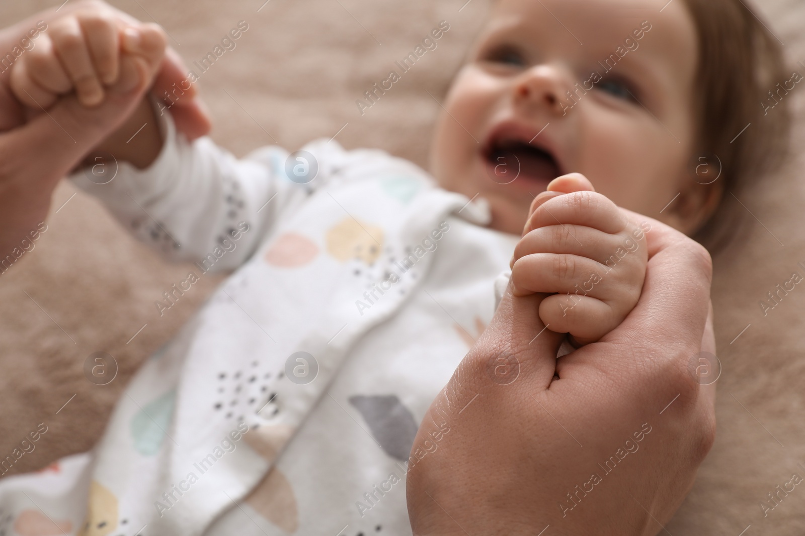 Photo of Father playing with his daughter on blanket, closeup