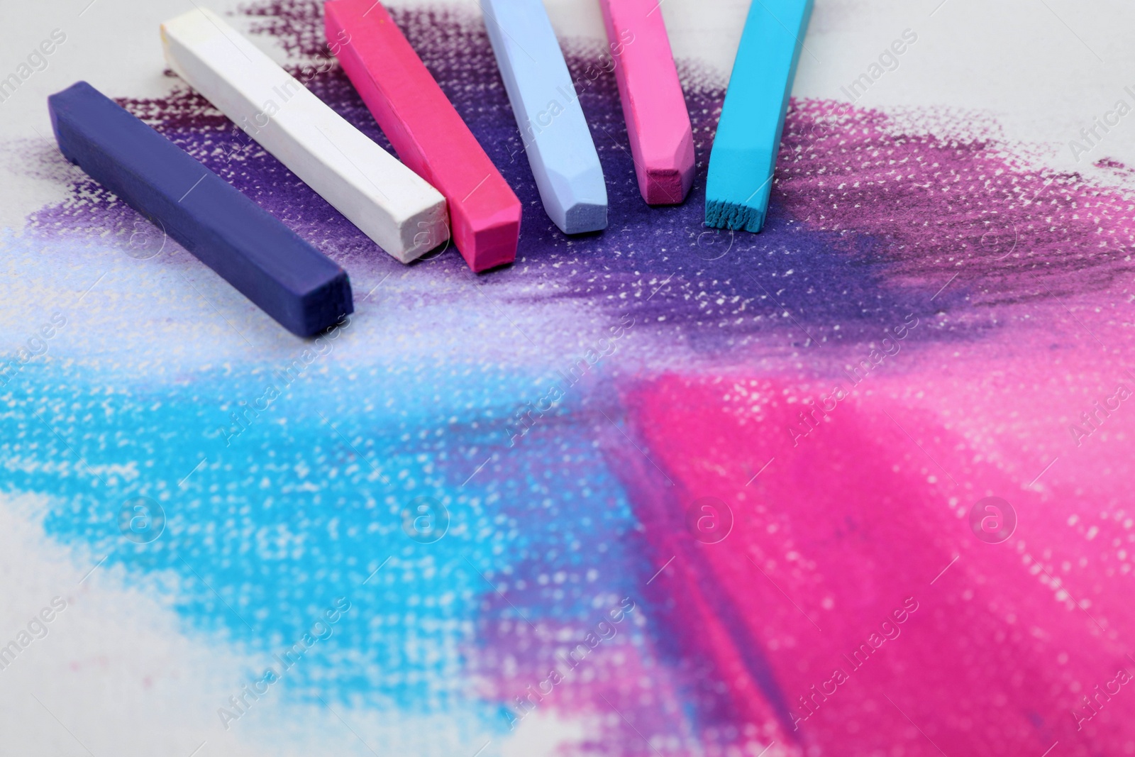 Photo of Colorful pastel chalks on abstract drawing. Space for text