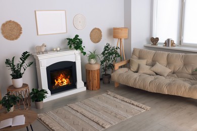 Photo of Beautiful living room interior with fireplace, green houseplants and comfortable sofa