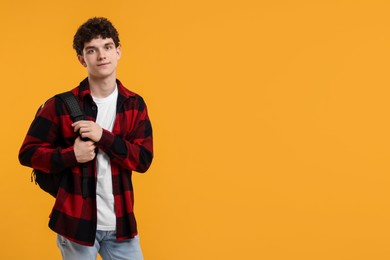 Photo of Portrait of student with backpack on orange background. Space for text