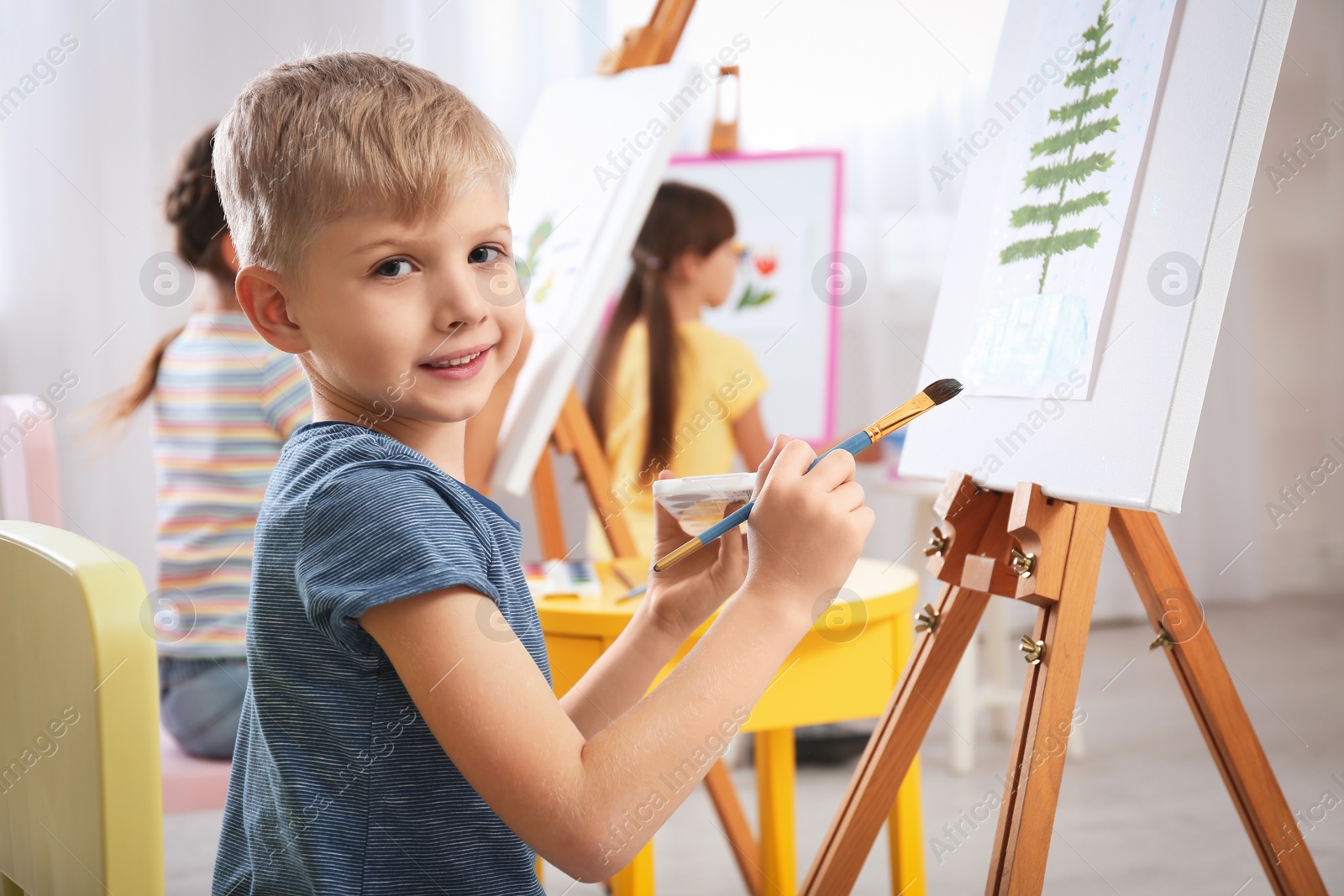 Photo of Cute little child painting during lesson in room