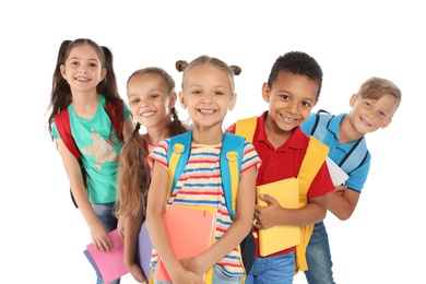 Group of little children with backpacks and school supplies on white background