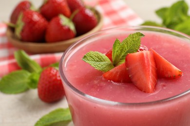 Photo of Delicious strawberry mousse with mint in glass, closeup