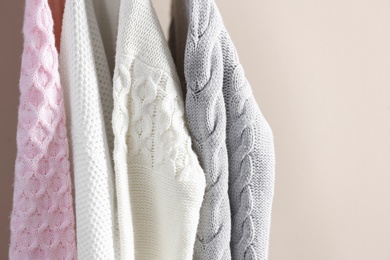 Collection of warm sweaters on light background, closeup