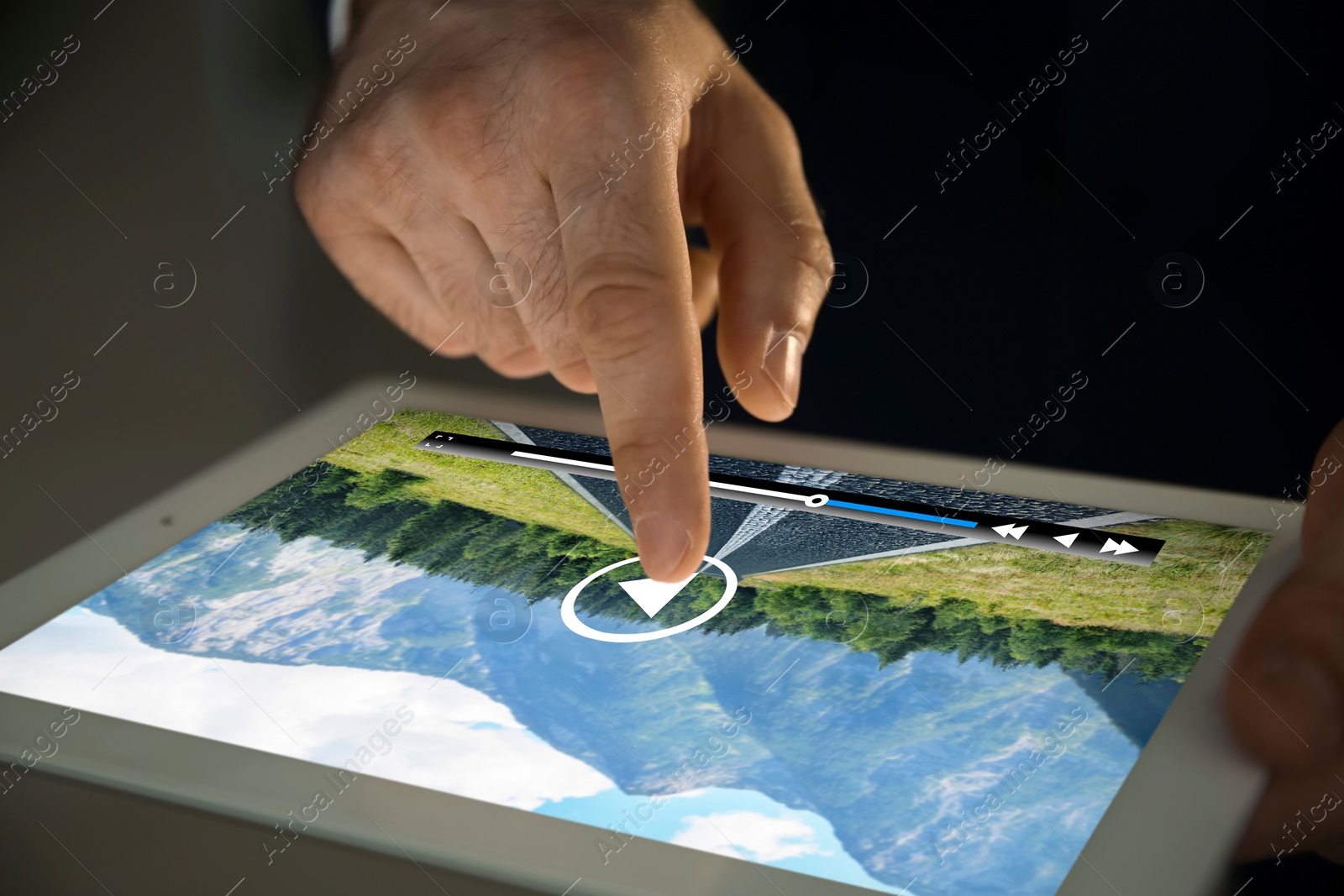 Image of Man touching tablet screen to play video, closeup