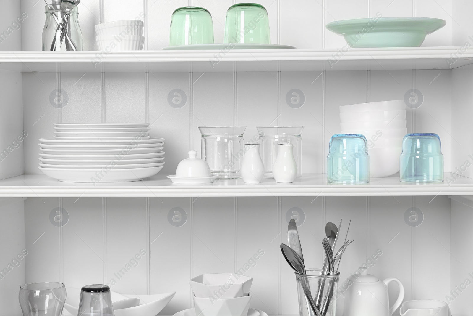 Photo of White shelving unit with set of dishware