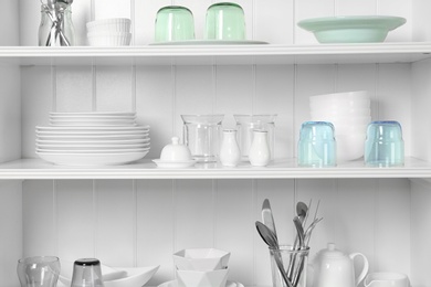 Photo of White shelving unit with set of dishware